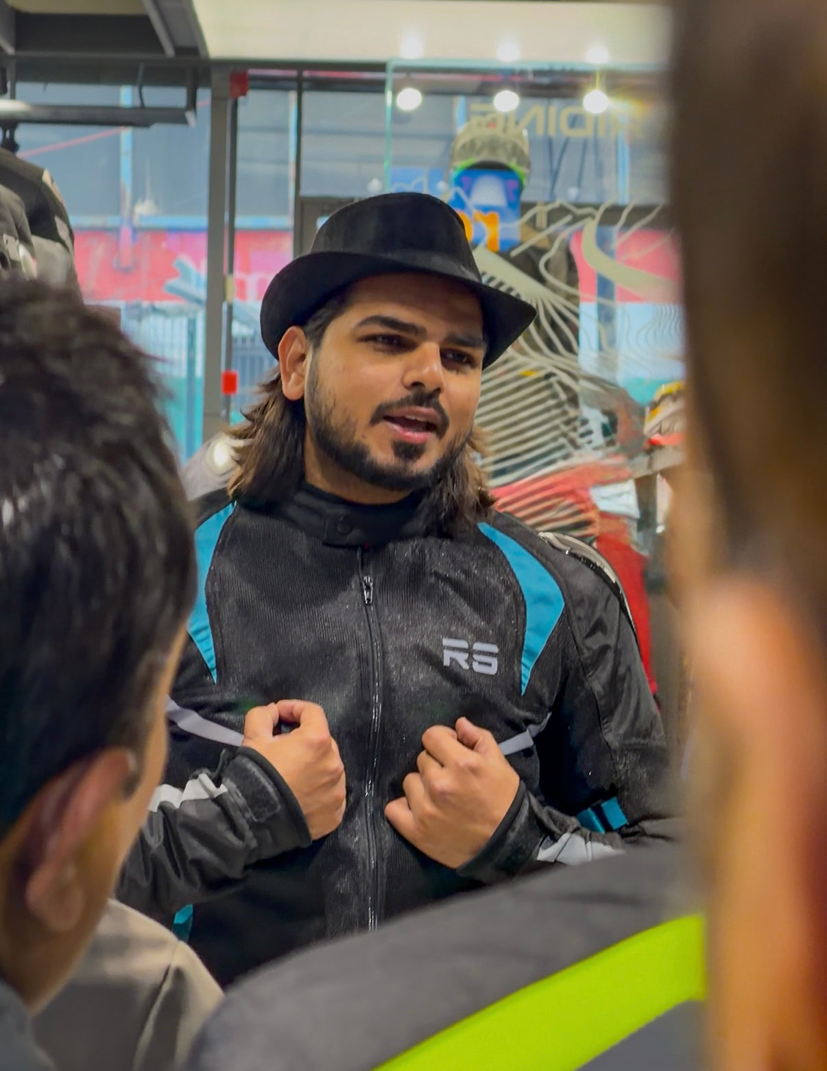 Man wearing a black jacket with 'RS' branding in a store setting